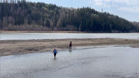 Two members of Quaternary Palaeontology cross part of the river.