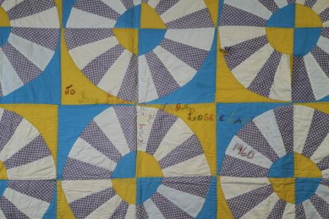 A close up of Lossie Lane's Wagon Wheel quilt showing the inscription "To Ivy Beaver. Remember Me. From Lossie Lane. 1960"