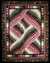 Photo of an intricate Bargello quilt made by Christine Beaver. The pattern of various squares forms swirls of beiges, greens, browns, reds and pinks in the centre.