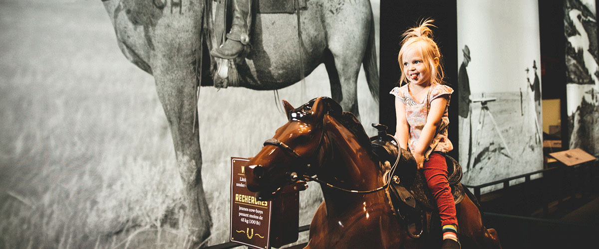 A little girl riding an electric horse