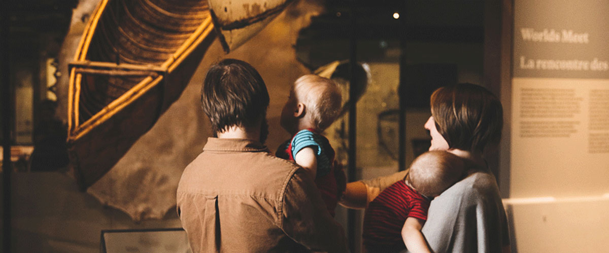 A family looks at an exhibit in the Human History Hall.