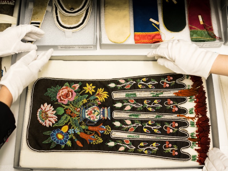 Curators displaying a fire bag from the collection.
