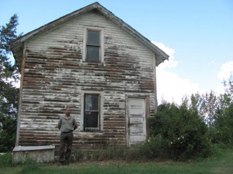 Paul stands in front of his grandparents’ two-storey house. 