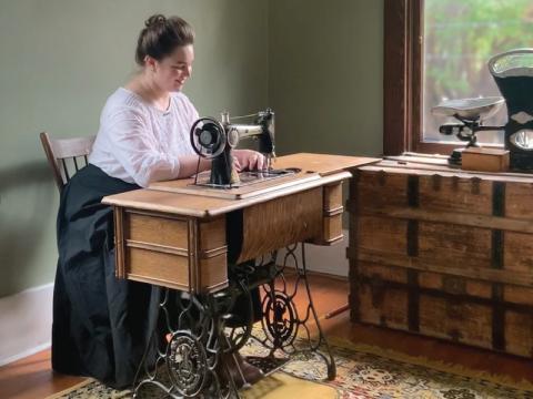 Nancy sewing at an old sewing table