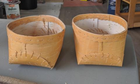 Two hand-made birch baskets sit on a table