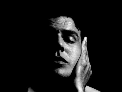 close up photo of a man with a hand on his left cheek