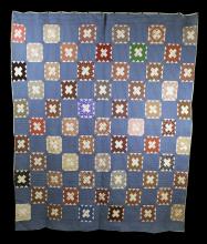 A quilt with a blue background, and a multi-coloured pattern of squares with white x's in the middle. 