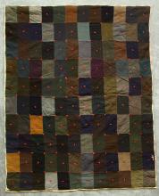 A quilt featuring rectangles of greens, browns, blues and whites.