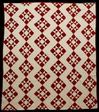A red and white quilt featuring star-shaped squares in a regular pattern.