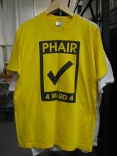 A yellow T-shirt hanging on a wooden hanger. The words "Phair 4 Ward 4" and a big checkmark are printed on the shirt.