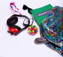 a sensory kit bag with headphones, sunglasses, and other helpful items