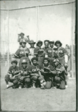 A black and white photo of a group of young female baseball players.