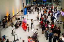 Looking down at the Royal Alberta Museum lobby from the main staircase. We can see a large group of people watching traditional Mexican dancers and musicians performing for the opening event of Death: Life's Greatest Mystery.